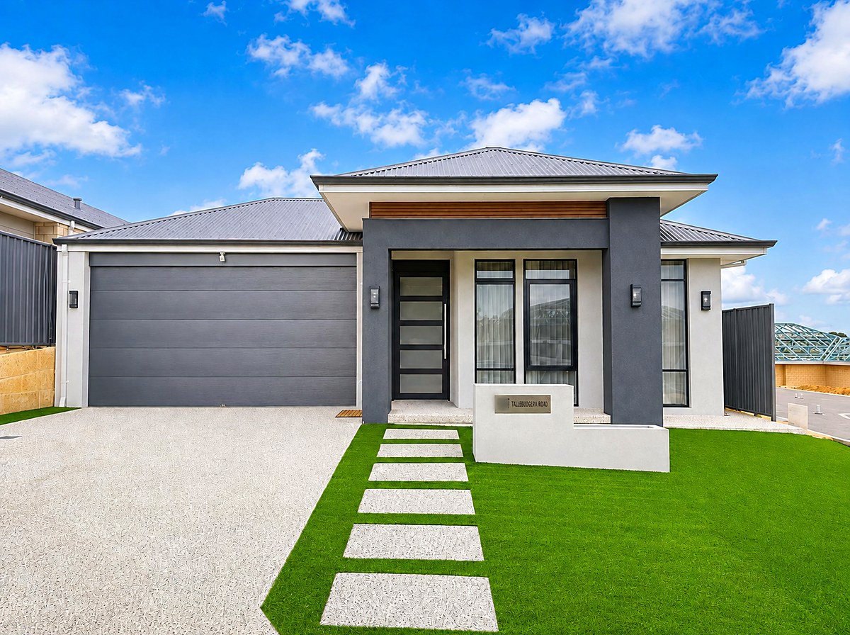 Young couple holding keys in front of their new modern Perth home at sunset